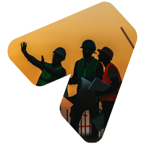 Three construction workers on a roof, studying blueprints as dusk sets behind them