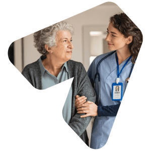 An aged care worker standing side-by-side and making eye contact with a resident / patient