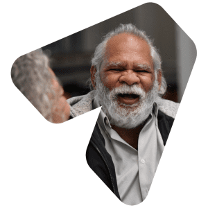 An older Indigenous Australian man smiles broadly