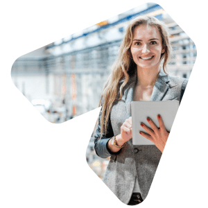 A young, female retail employee stands in a warehouse while scrolling on an ipad